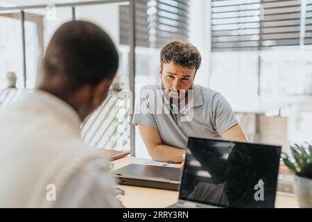 Les professionnels du marketing collaborent dans un bureau diversifié, en se concentrant sur la gestion de la marque, la communication et la stratégie de contenu pour engager les clients et opter Banque D'Images