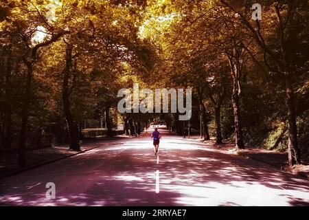 Marathon urbain : homme sprintant dans les rues de la ville dans chaussures de course Banque D'Images