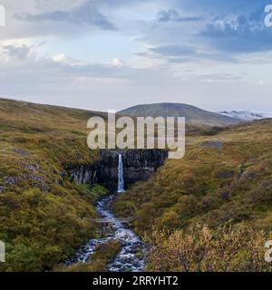 Pittoresque cascade Svartifoss (islandais pour "cascade noire", entourée de colonnes de basalte de lave sombre) vue d'automne, parc national de Skaftafell, Icel Banque D'Images