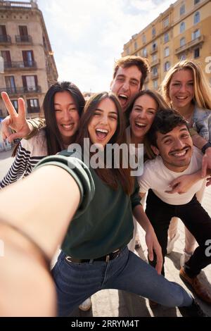 Selfie vertical de groupe de jeunes amis multi-ethniques s'amusant ensemble à l'extérieur. Des gens excités. Banque D'Images