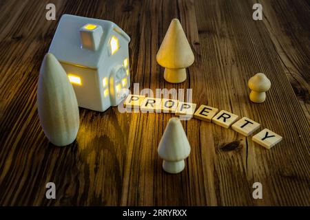 propriété lettres en bois fond de maison en céramique, crise du logement agence immobilière concept de propriété à domicile Banque D'Images