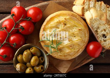 Savoureux fromage brie cuit servi sur une table en bois, vue de dessus Banque D'Images