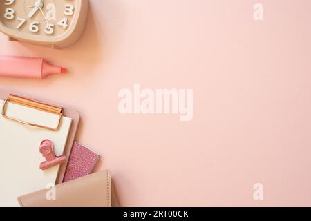 Cahier rose, presse-papiers, clip, pochette, surligneur, horloge sur fond de bureau rose. pose à plat, vue de dessus, espace de copie. espace de travail Banque D'Images