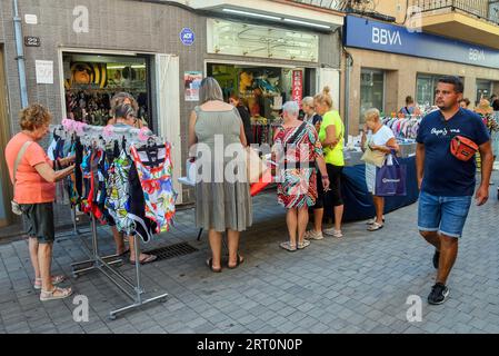 Calafell, Espagne. 09 août 2023. Les gens regardent les rabais dans un magasin de rue au marché de vente de liquidation. La mairie de Calafell, en collaboration avec l'association des marchands, a organisé un forum de marché boursier ou de vente de liquidation, où plusieurs magasins de vêtements et d'accessoires ont installé des stands dans la rue afin que les entreprises puissent vendre leurs produits excédentaires. Crédit : SOPA Images Limited/Alamy Live News Banque D'Images