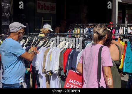 Calafell, Tarragone, Espagne. 9 août 2023. Les gens regardent les rabais dans un magasin de rue au marché de vente de liquidation. La mairie de Calafell, en collaboration avec l'association des marchands, a organisé un forum de marché boursier ou de vente de liquidation, où plusieurs magasins de vêtements et d'accessoires ont installé des stands dans la rue afin que les entreprises puissent vendre leurs produits excédentaires. (Image de crédit : © Ramon Costa/SOPA Images via ZUMA Press Wire) USAGE ÉDITORIAL SEULEMENT! Non destiné à UN USAGE commercial ! Banque D'Images