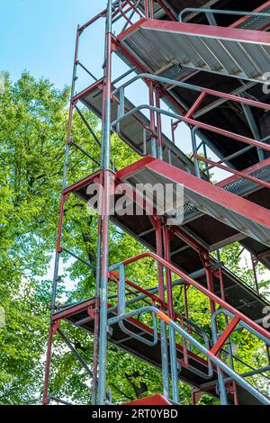 Construction d'échafaudages sur fond d'arbres et de ciel bleu. Banque D'Images