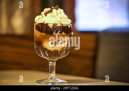 Chocolat chaud décadent garni de crème chantilly et de copeaux de chocolat Banque D'Images