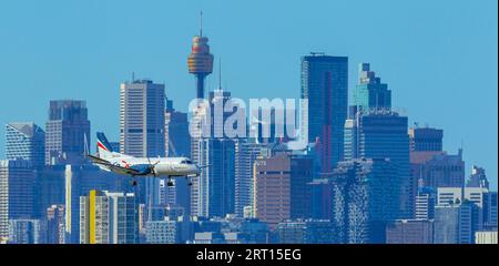 Les gratte-ciel de Sydney, en Australie, avec un avion Rex Regional Express descendant vers l'aéroport de Sydney. Banque D'Images