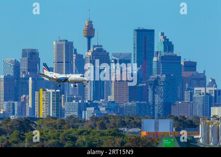 Les gratte-ciel de Sydney, en Australie, avec un avion Rex Regional Express descendant vers l'aéroport de Sydney. Banque D'Images