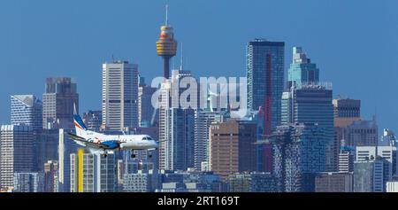 Les gratte-ciel de Sydney, en Australie, avec un avion Rex Regional Express descendant vers l'aéroport de Sydney. Banque D'Images