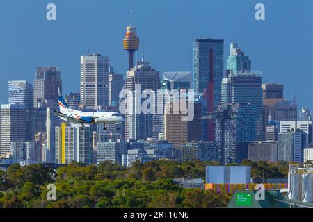 Les gratte-ciel de Sydney, en Australie, avec un avion Rex Regional Express descendant vers l'aéroport de Sydney. Banque D'Images