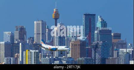 Les gratte-ciel de Sydney, en Australie, avec un avion Rex Regional Express descendant vers l'aéroport de Sydney. Banque D'Images