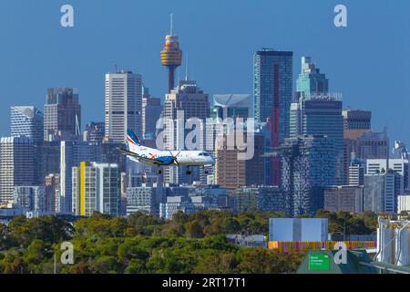 Les gratte-ciel de Sydney, en Australie, avec un avion Rex Regional Express descendant vers l'aéroport de Sydney. Banque D'Images