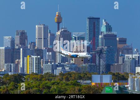 Les gratte-ciel de Sydney, en Australie, avec un avion Rex Regional Express descendant vers l'aéroport de Sydney. Banque D'Images