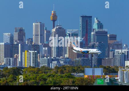 Les gratte-ciel de Sydney, en Australie, avec un avion Rex Regional Express descendant vers l'aéroport de Sydney. Banque D'Images