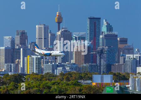 Les gratte-ciel de Sydney, en Australie, avec un avion Rex Regional Express descendant vers l'aéroport de Sydney. Banque D'Images