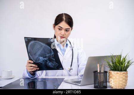 Femme médecin vérifiant le film radiographique dans le laboratoire médical à l'hôpital. Banque D'Images