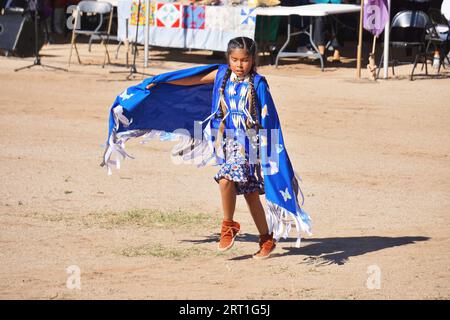 Une jeune danseuse amérindienne se soucie de ses pas alors qu'elle participe à une danse au châle lors d'un pow-wow dans la réserve de San Xavier, près de Tucson, Arizona. Banque D'Images