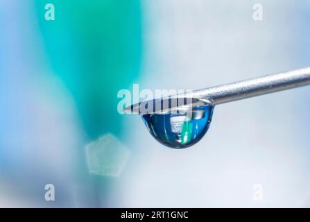 Macro image vaccin Covid, une goutte de vaccin Moderna est accrochée à une aiguille vaccinale Banque D'Images