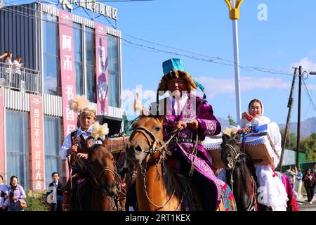 ALTAY, CHINE - 10 SEPTEMBRE 2023 - des éleveurs conduisent des chameaux et des moutons pour montrer l'activité de transformation culturelle nomade dans la zone urbaine d'Altay, Xi Banque D'Images