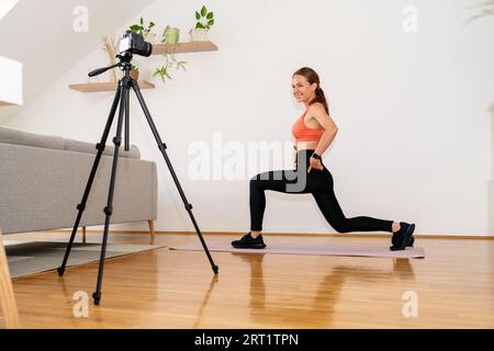 Athletic Woman entraîneur de fitness en ligne vlogger enregistrant la vidéo de l'exercice sportif pour ses médias sociaux. Banque D'Images