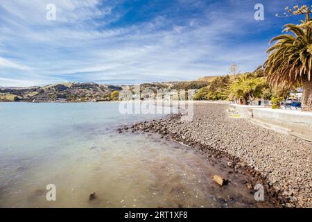 Plage et l'eau dans l'établissement français d'Akaroa sur la péninsule de Banks en Nouvelle Zélande Banque D'Images