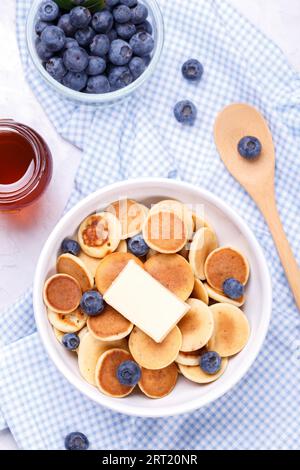 Mini crêpes aux céréales maison avec miel et bleuets sur fond de pierre grise, gros plan, verticales Banque D'Images