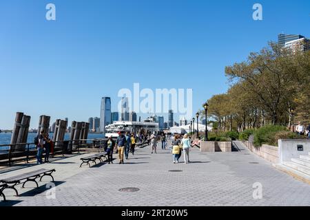 New York, États-Unis d'Amérique, 19 septembre 2019 : les gens profitent du soleil sur la promenade au bord de l'eau de Battery Park Banque D'Images