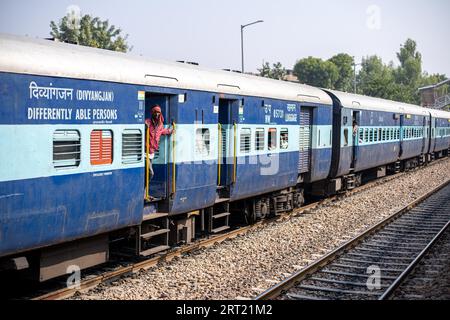 Jodhpur, Inde, 10 décembre 2019 : un homme debout à la porte d'un train indien Banque D'Images