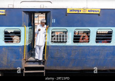 Jodhpur, Inde, 10 décembre 2019 : un homme debout à la porte d'un train indien Banque D'Images