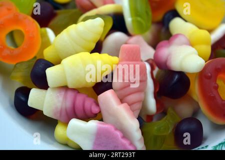 Gelée brillante, juteuse et inhabituelle, gommes, bonbons de différentes formes et tailles disposés sur un fond blanc mat. Bonbons ukrainiens fabriqués en Ukraine Banque D'Images