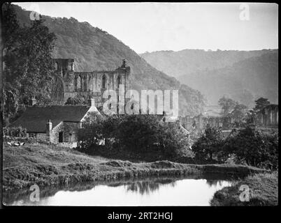 Abbaye de Rievaulx, Rievaulx, Ryedale, North Yorkshire, 1924-1929. Une vue sur l'abbaye de Rievaulx avec la rivière Rye et un chalet au premier plan. Banque D'Images