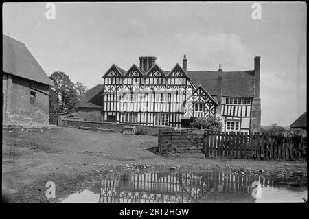 Middle Beanhall Farm, Church Road, Bradley Green, Feckenham, Redditch, Worcestershire, c1920. Une vue de l'ouest vers l'avant de la ferme à ossature de bois du 16e siècle à Middle Beanhall Farm, avec un étang au premier plan. Banque D'Images