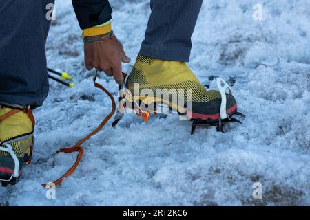 Alpiniste portant les crampons pour marcher sur la glace et grimper le glacier de montagne jusqu'au sommet. gros plan. Parc national du Gran Paradiso. Banque D'Images
