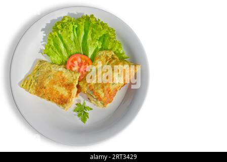 Riche omelette farcie de fromage fondu avec salade d'accompagnement. Fond blanc isolé Banque D'Images