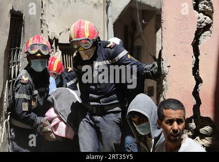 Marrakech. 10 septembre 2023. Les sauveteurs portent le corps d’une victime près de l’épicentre du village d’Amizmiz au Maroc, le 10 septembre 2023. Un tremblement de terre de magnitude 6,8 a frappé le Maroc vendredi. L’épicentre du tremblement de terre se trouvait près de la ville d’Ighil, dans la province d’Al Haouz, à environ 70 km au sud-ouest de Marrakech. Le séisme a coûté la vie à 2 012 personnes et en a blessé 2 059, dont 1 404 dans un état grave, selon la dernière mise à jour du ministère de l'intérieur du pays samedi. Crédit : Wang Dongzhen/Xinhua/Alamy Live News Banque D'Images