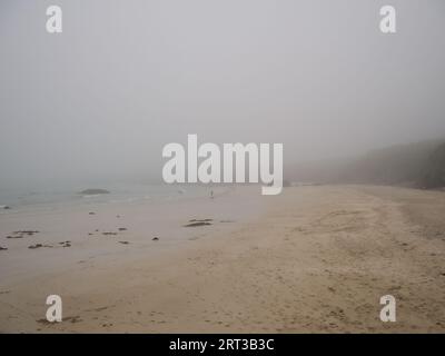 Une personne seule sur la plage du port de Ness sur l'île de Lewis, Hébrides extérieures, Écosse, Royaume-Uni. Pris un jour de dreich - humide et brumeux. Banque D'Images