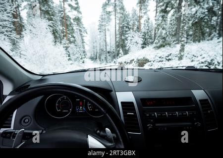 Vue de la forêt enneigée avec des arbres couverts de neige vu de l'intérieur de la voiture tout en conduisant sur la route Banque D'Images