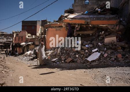 Azizmiz, Maroc. 10 septembre 2023. Un homme âgé avec un bâton de marche passe devant une maison effondrée dans la ville d'Azizmiz. Le tremblement de terre qui a frappé le Maroc vendredi 8 septembre a été le pire de l'histoire du pays, faisant plus de 2 000 morts. Crédit : SOPA Images Limited/Alamy Live News Banque D'Images