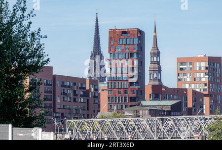 Hambourg, Allemagne. 04 septembre 2023. Vue de la tour résidentielle de luxe 'Cinnamon Tower' à HafenCity avec les tours de la Hauptkirche Sankt Nikolai (l) et la Hauptkirche Sankt Katharinen (r) en arrière-plan. Crédit : Markus Scholz/dpa/Picture alliance/dpa | Markus Scholz/dpa/Alamy Live News Banque D'Images