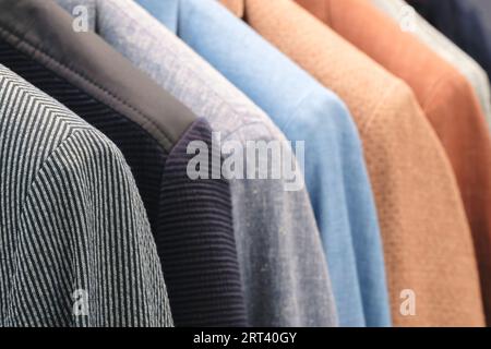 Racks avec différents costumes pour hommes dans une boutique de vêtements pour hommes. Banque D'Images