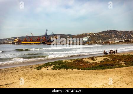 Une belle plage à Ensenada avec le port en arrière-plan et les gens à cheval par la mer, c'est l'un des meilleurs endroits touristiques de Baja Cali Banque D'Images