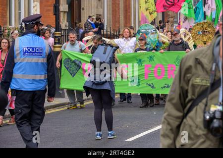 LONDRES - 22 avril 2023 : une photographe capture extinction Rebellion Protest, en se concentrant sur la bannière de protestation au début de la marche, avec un M. Banque D'Images