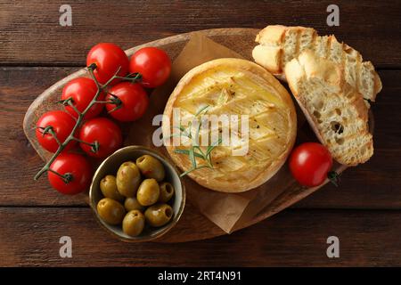 Savoureux fromage brie cuit servi sur une table en bois, vue de dessus Banque D'Images