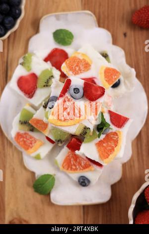 Top View Homemade Healthy Greek Yogurt Frozen Bark Bar avec divers fruits frais, baies, kiwi et orange Banque D'Images
