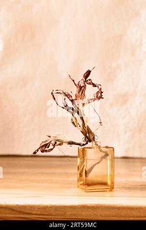 Fleurs séchées rouges dans un vase en verre sur une table en bois , activité romantique , moment dédié aux souvenirs Banque D'Images