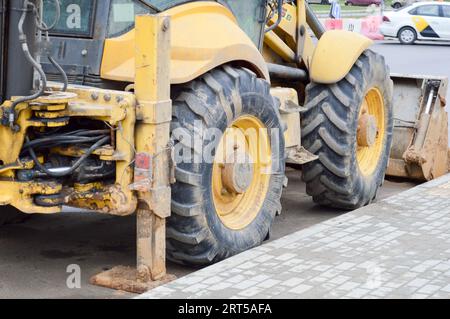 Grand tracteur de pelle hydraulique lourde industrielle, puissant et jaune vif, bulldozer, équipement de construction spécialisé pour la réparation sur route pendant la construction o Banque D'Images