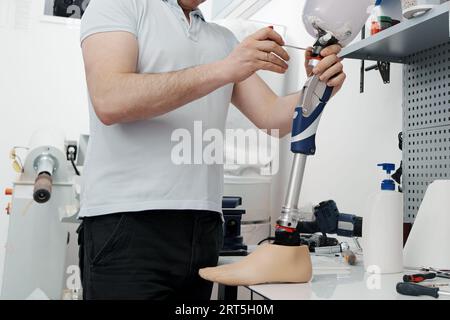 Récolte d'artisan méconnaissable ajustement et flexion de la jambe prothétique moderne à la section du genou Banque D'Images