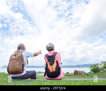 Vue arrière couple Senior randonnée sur la montagne Banque D'Images
