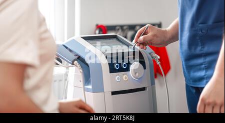 Le médecin physiothérapeute utilise des équipements médicaux pour un traitement efficace de la douleur. Banque D'Images